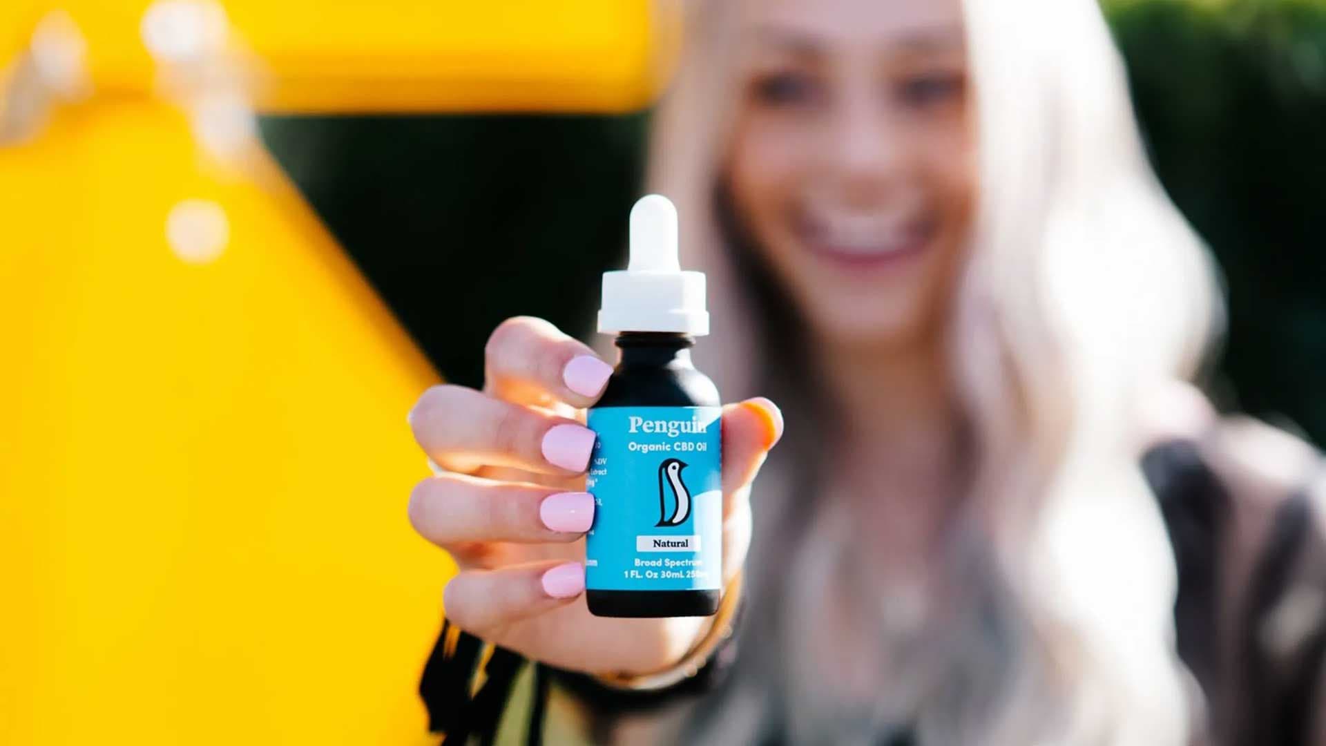 Happy woman holding CBD Oil